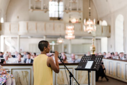 Sängerin singt in der Kirche bei der Trauung von Brautpaar Petra und Daniel bei ihrer Hochzeit in der Kirche in Schweden fotografiert von Hochzeitsfotograf Veronika Anna Fotografie aus München