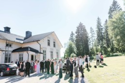 Hochzeitsgäste vor der Kirche am Hochzeitstag von Brautpaar Petra und Daniel nach ihrer Trauung in der Kirche in Schweden fotografiert von Hochzeitsfotograf Veronika Anna Fotografie aus München