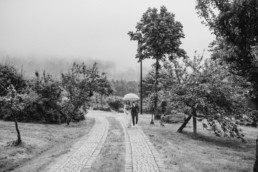 Regenhochzeit, Brautpaar unter dem Schirm bei Hochzeit am Grandsberger Hof