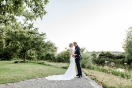 Brautpaat in verliebter Pose am Hofgut Hafnertleiten bei Gartenhochzeit im Sommer